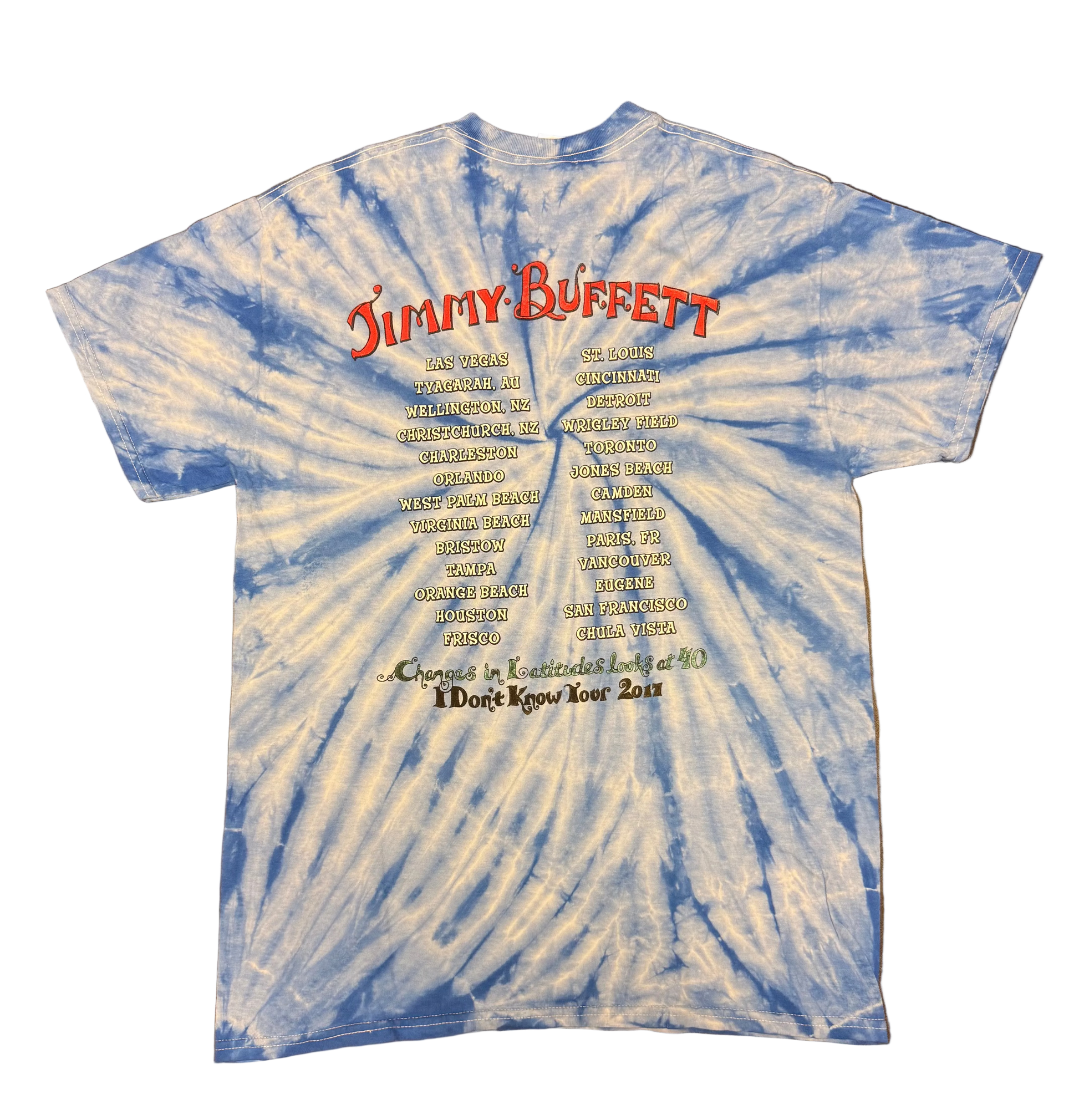 Back of a blue and white tie dye short sleeve Jimmy Buffett tee featuring large red “Jimmy Buffett” lettering above two columns of 2017 tour cities. The bottom reads “Changes in Latitudes Looks at 40” and “I Don’t Know Tour 2017.”