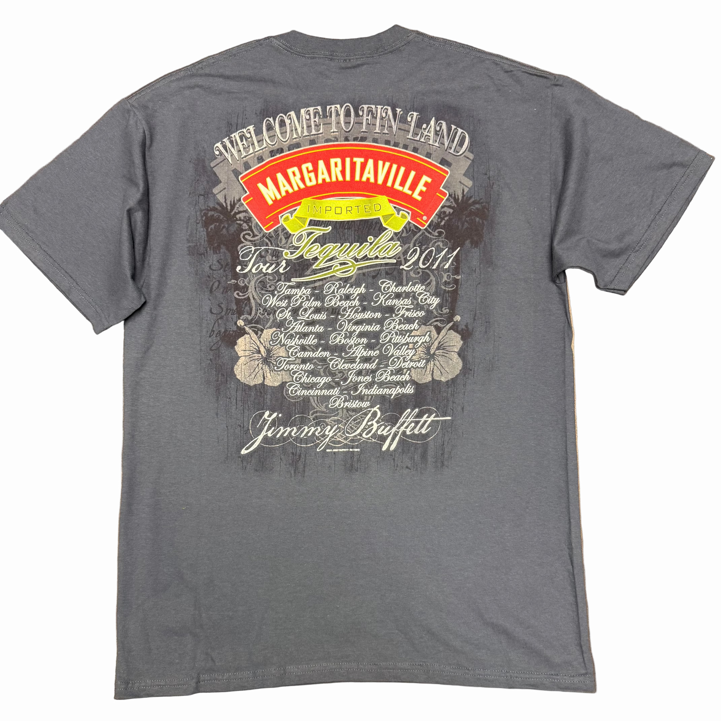 Back of a charcoal blue slate short sleeve Jimmy Buffett tee featuring large “Welcome to Fin Land” and Margaritaville Tequila Tour 2011 artwork. A list of tour cities appears in white script at center, framed by hibiscus flowers and distressed graphics, with Jimmy Buffett lettering along the bottom.
