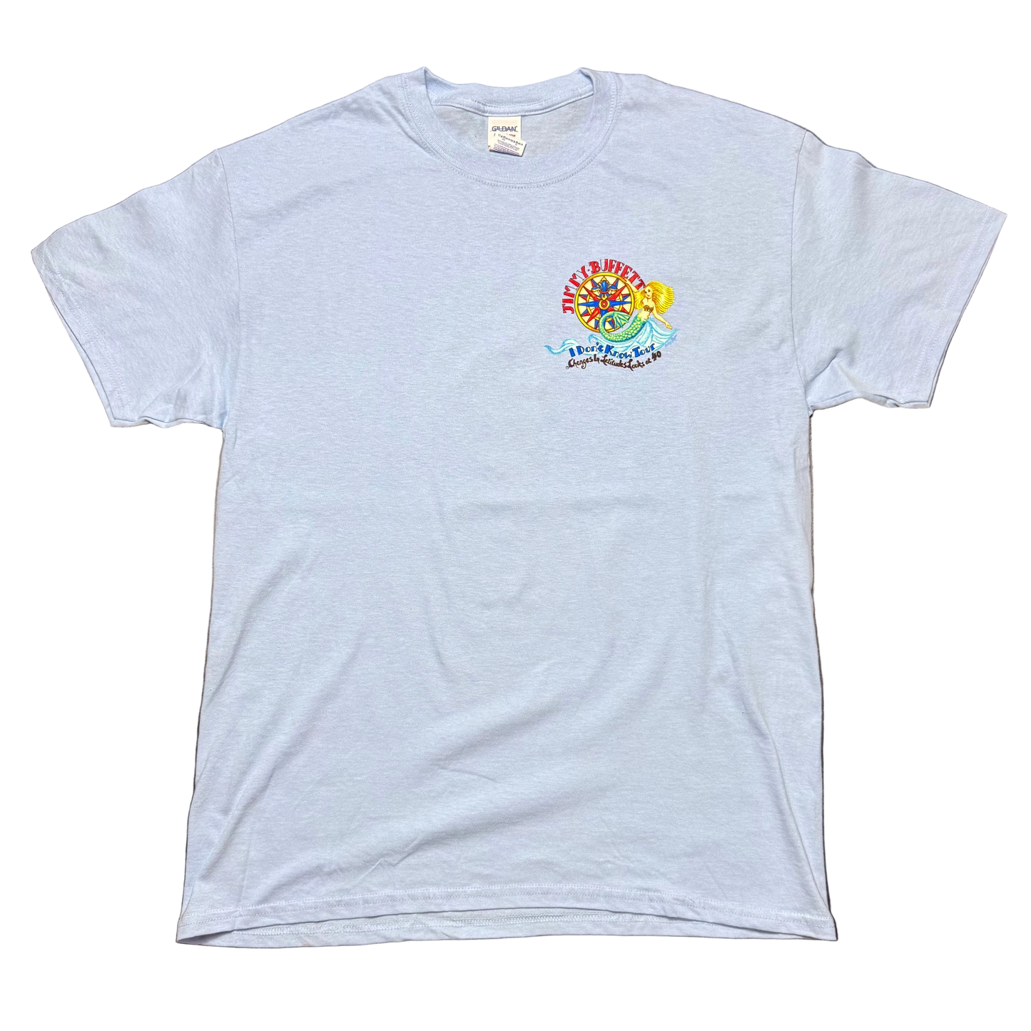 Light blue short sleeve Jimmy Buffett tee featuring a small left chest graphic with a colorful compass and mermaid design. “Jimmy Buffett” appears above the artwork, with “I Don’t Know Tour” and “Changes in Latitudes Looks at 40” printed below.