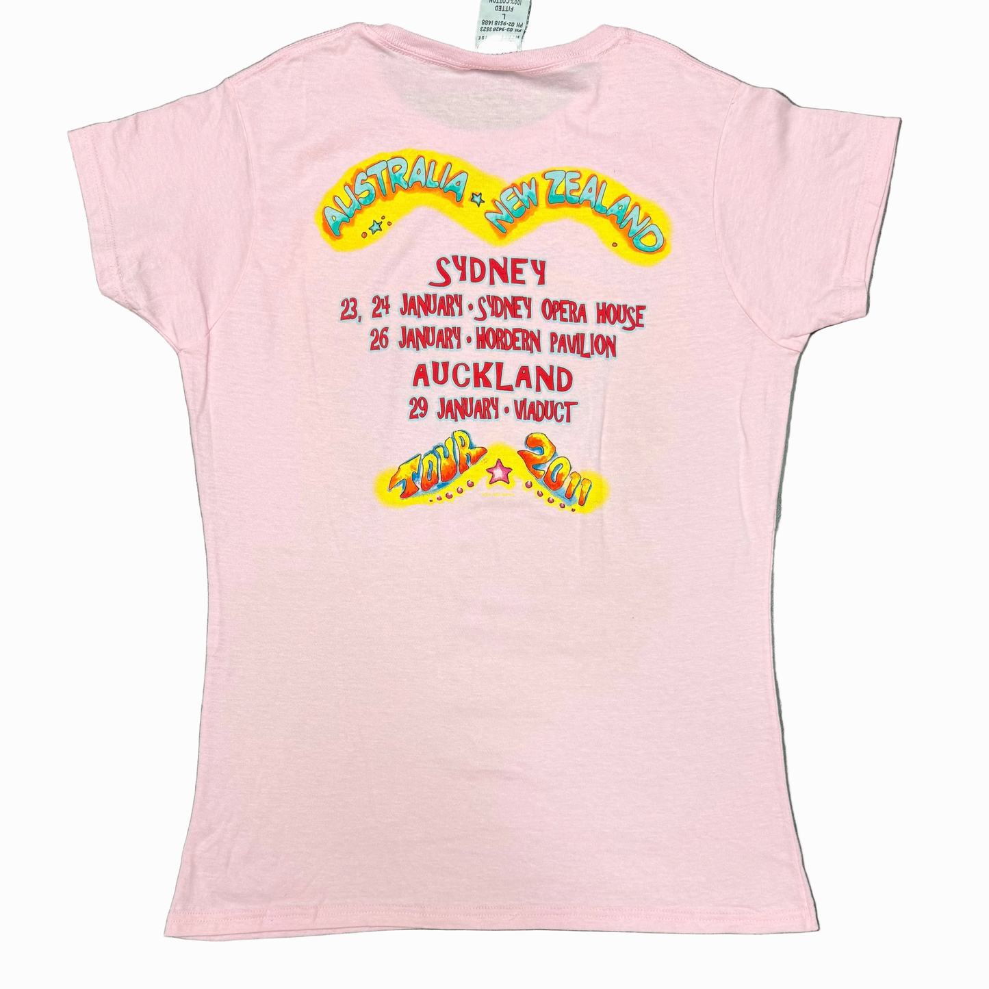 Back of a light pink women’s short sleeve Jimmy Buffett tee featuring large “Australia + New Zealand” lettering above the 2011 tour dates. The design lists Sydney performances at the Sydney Opera House on January 23 and 24, Hordern Pavilion on January 26, and Auckland Viaduct on January 29, with colorful “Tour 2011” artwork at the bottom.