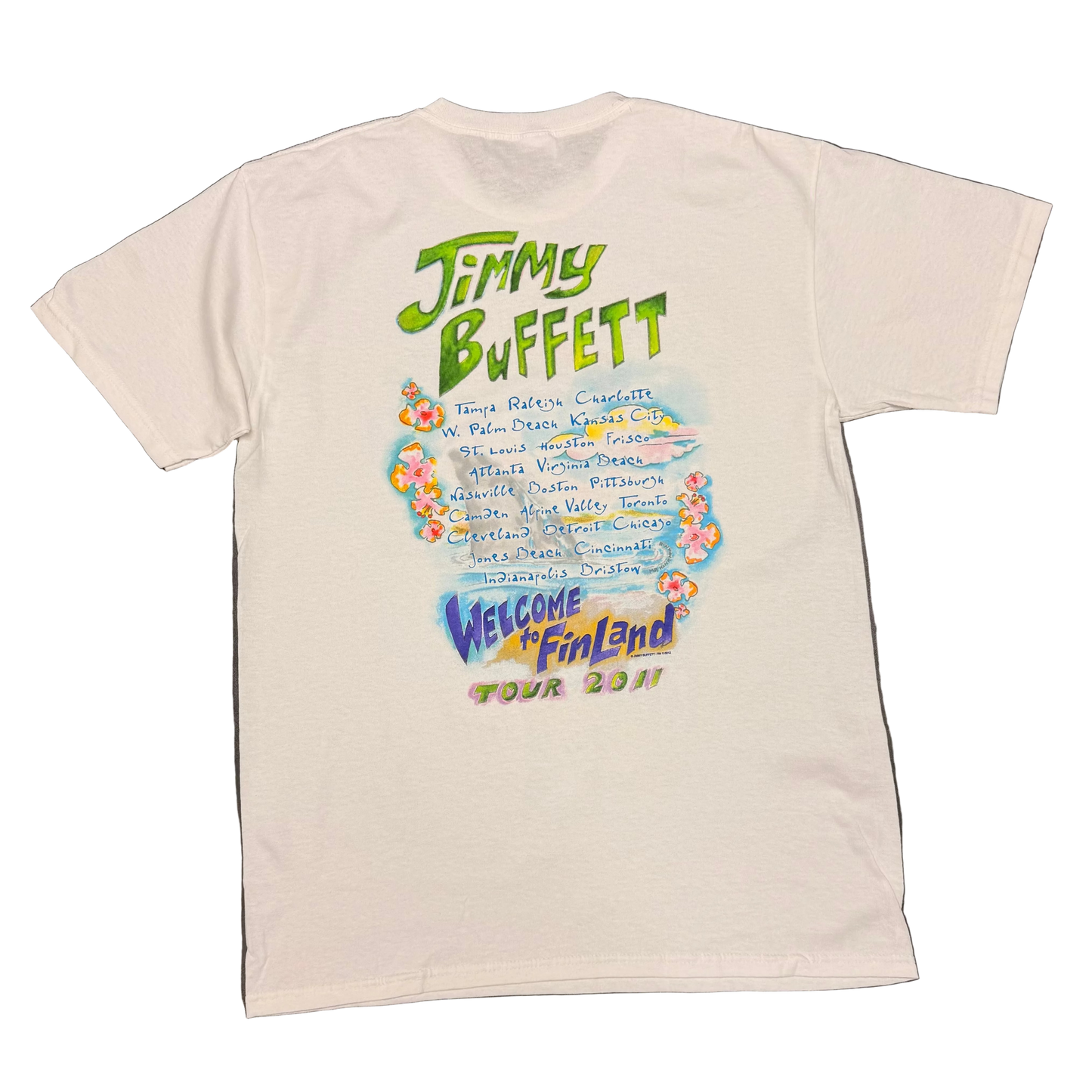 Back of a white short sleeve Jimmy Buffett tee featuring large green “Jimmy Buffett” lettering above a handwritten style list of 2011 tour cities, surrounded by small tropical flower graphics. “Welcome to Fin Land Tour 2011” appears below in purple, yellow, pink, and green.