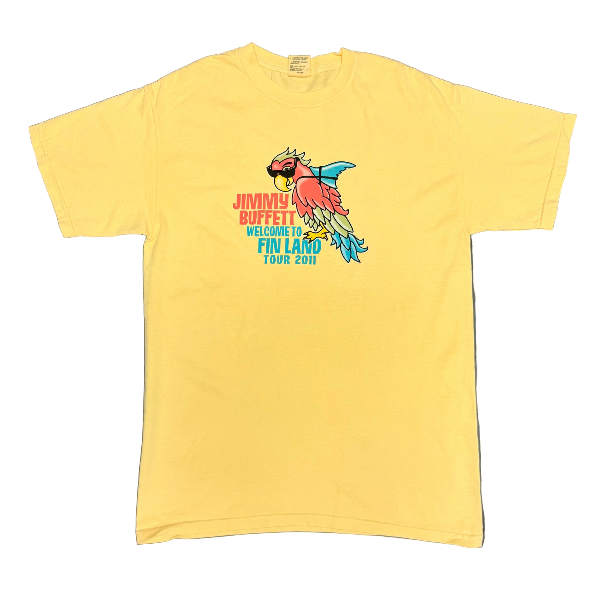 Light yellow short sleeve Jimmy Buffett tee featuring a colorful parrot wearing sunglasses with a blue shark fin strapped to its back. Red “Jimmy Buffett” lettering appears beside the artwork, with blue “Welcome to Fin Land” and “Tour 2011” text below.