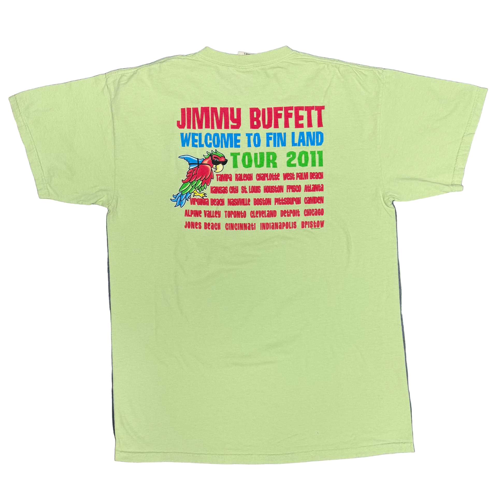 Back of a light green short sleeve Jimmy Buffett tee featuring large red “Jimmy Buffett” lettering above blue “Welcome to Fin Land Tour 2011” text. A smaller parrot with sunglasses and a shark fin appears beside a list of tour cities printed in red.