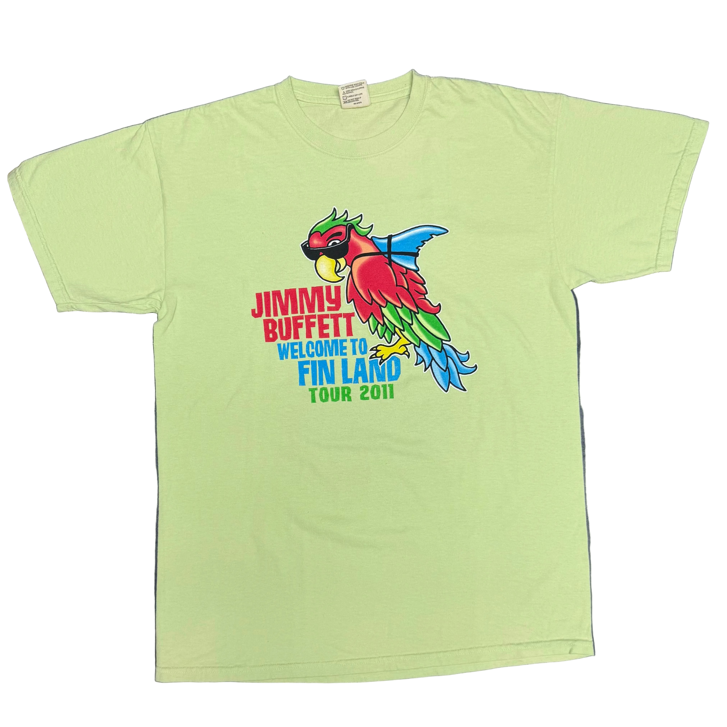 Light green short sleeve Jimmy Buffett tee featuring a colorful parrot wearing sunglasses with a blue shark fin strapped to its back. Red “Jimmy Buffett” lettering appears beside the artwork, with blue “Welcome to Fin Land” and “Tour 2011” text below.